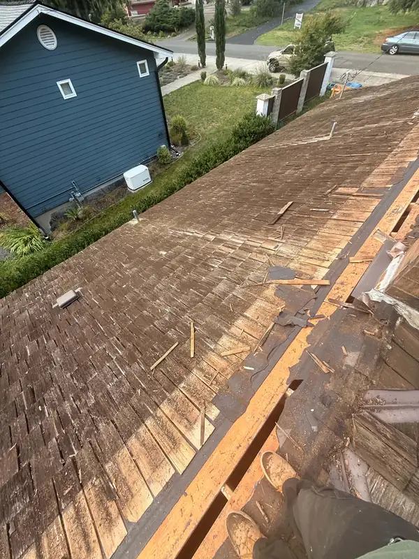 Worn cedar shake roof partly torn off
