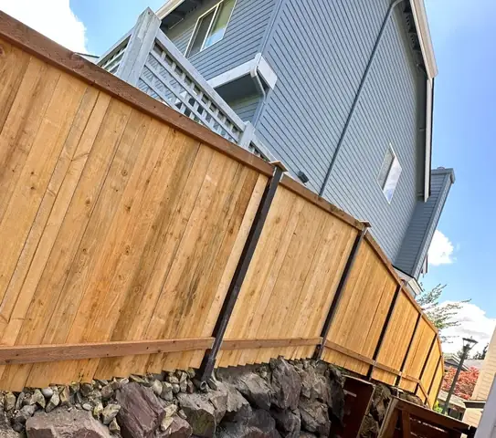 New cedar fence on a stone wall